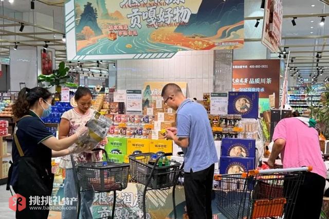 图为在都江堰市幸福广场幸福超市内采购农特产品的顾客们