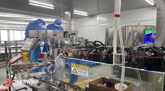 图为在允泰坊工厂内，工人们正在巡检黄鳝加工机器