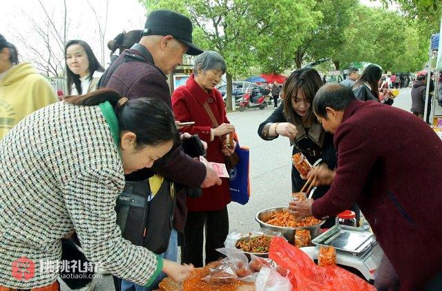 图为游客争相购买嘎嘣脆的鸡萝卜