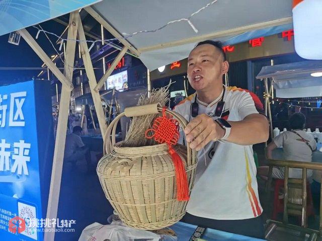 图为罗原正在“就业夜市”现场直播，宣传推广村里的土特产品