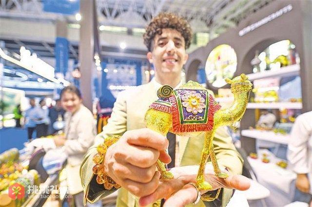 图为国外客商将一件件做工精美、极具地域特色的工艺品带到博览会上展示