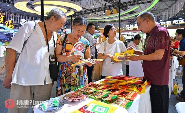 图为在第十一届四川农业博览会眉山场馆，游客正在选购仁寿特产