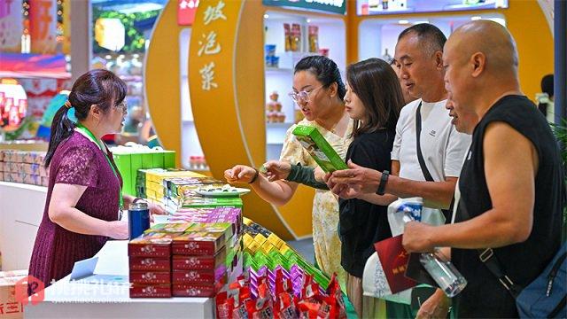 图为在第十一届四川农业博览会眉山场馆，游客正在选购仁寿芝麻糕
