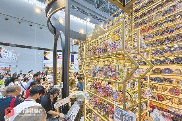 图为马来西亚参展商用包装精美的曲奇饼干盒搭起恢宏的 “城墙”，引来围观